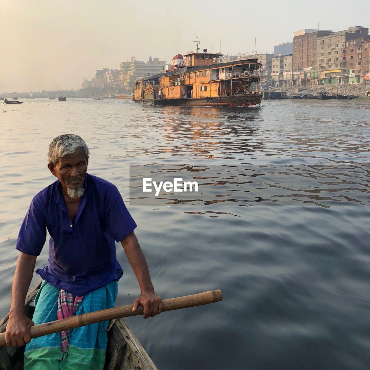 Man in boat against river buriganga 