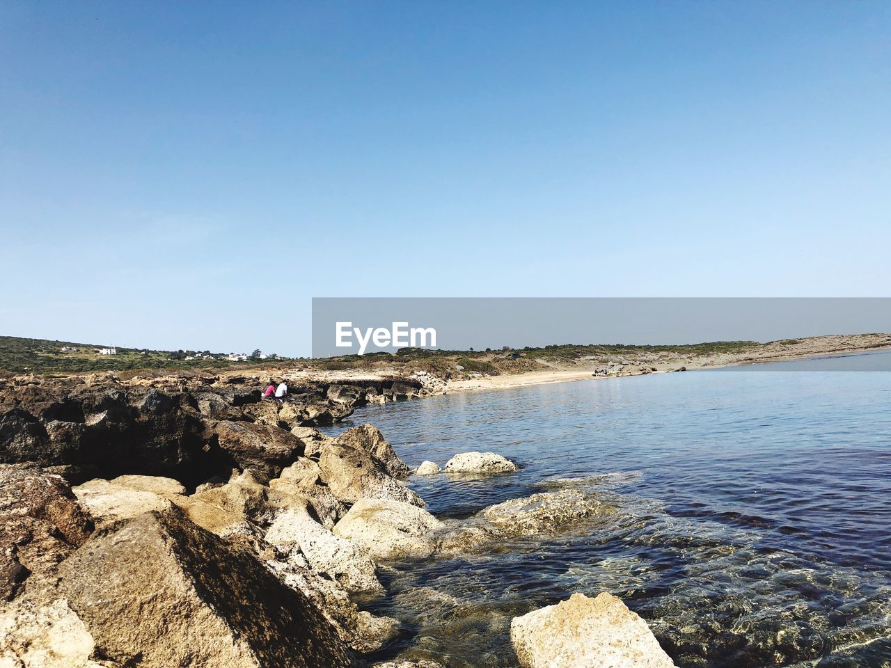 ROCKS ON SHORE AGAINST CLEAR SKY