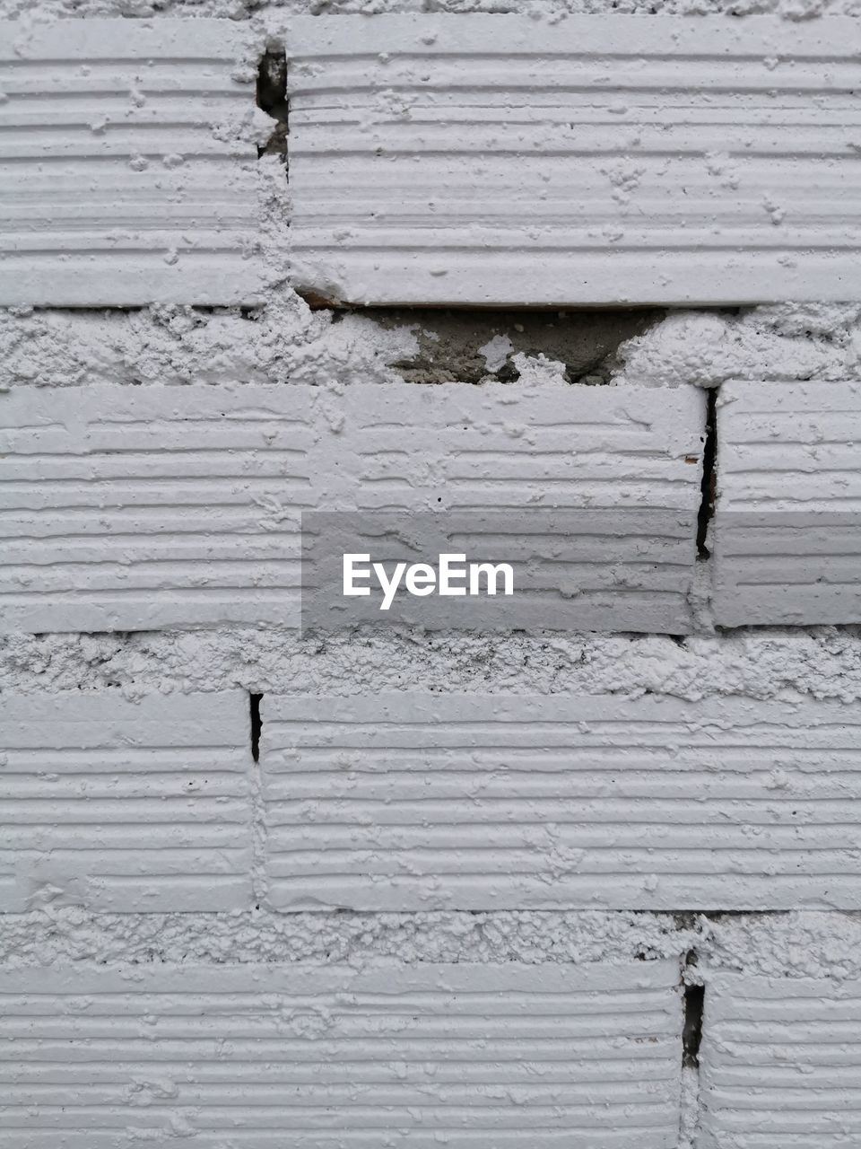 FULL FRAME SHOT OF WEATHERED WALL WITH UMBRELLA