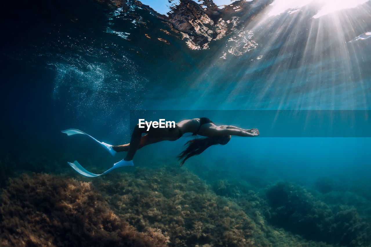 side view of man swimming in sea