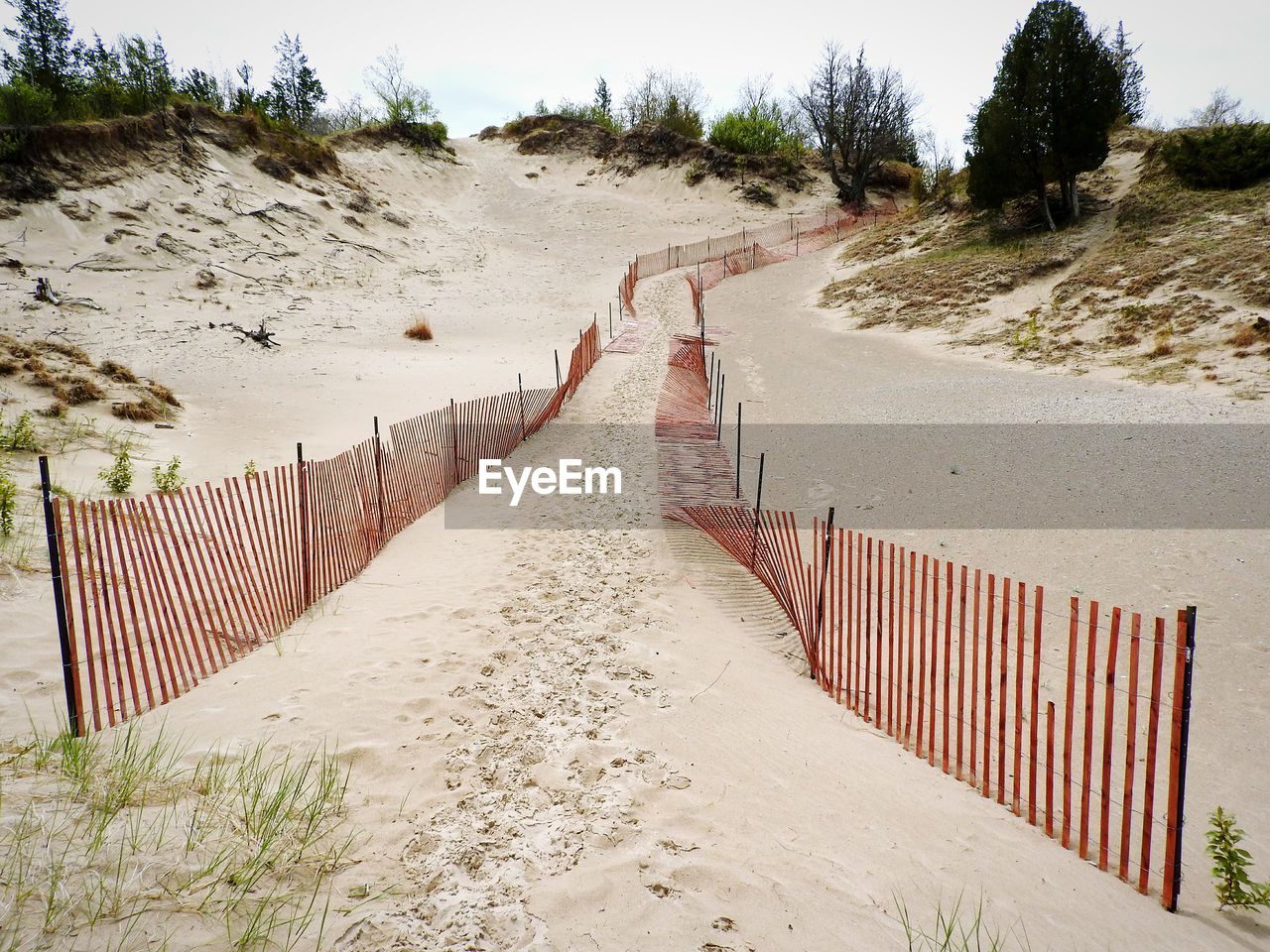 Footpath by fence on beach