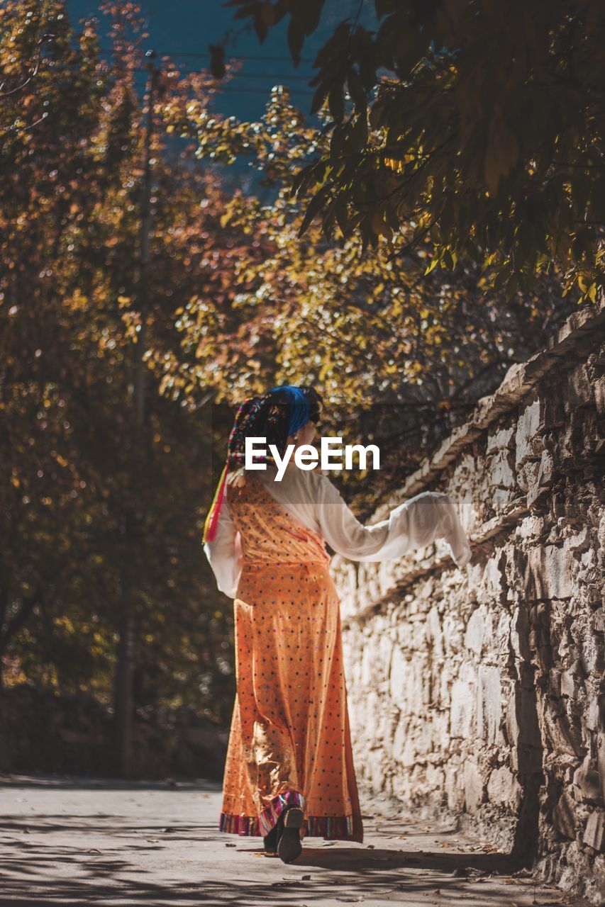 Rear view of woman in traditional clothing walking on footpath