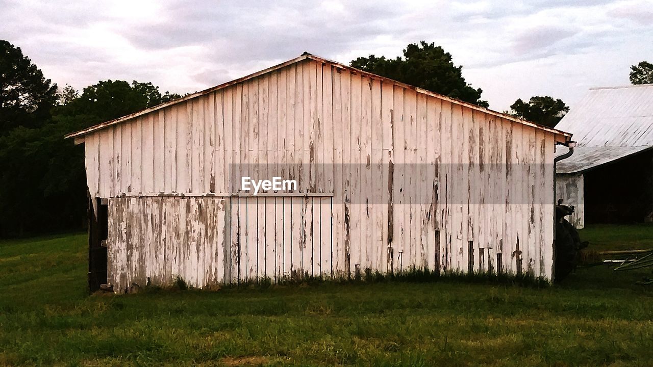 Barn on field against sky