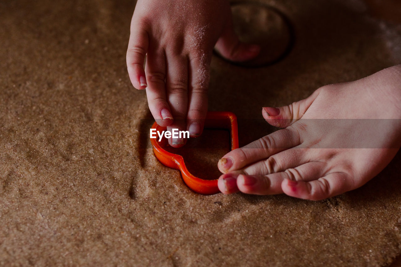 Close-up of baby hands making cookies of hear shape