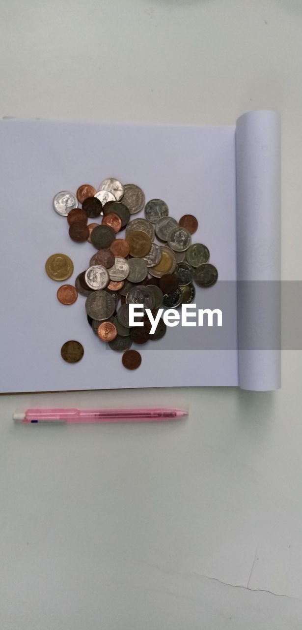 HIGH ANGLE VIEW OF COINS IN CONTAINER