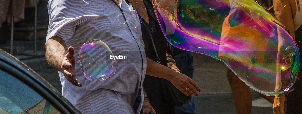 HIGH ANGLE VIEW OF MAN WITH BUBBLES