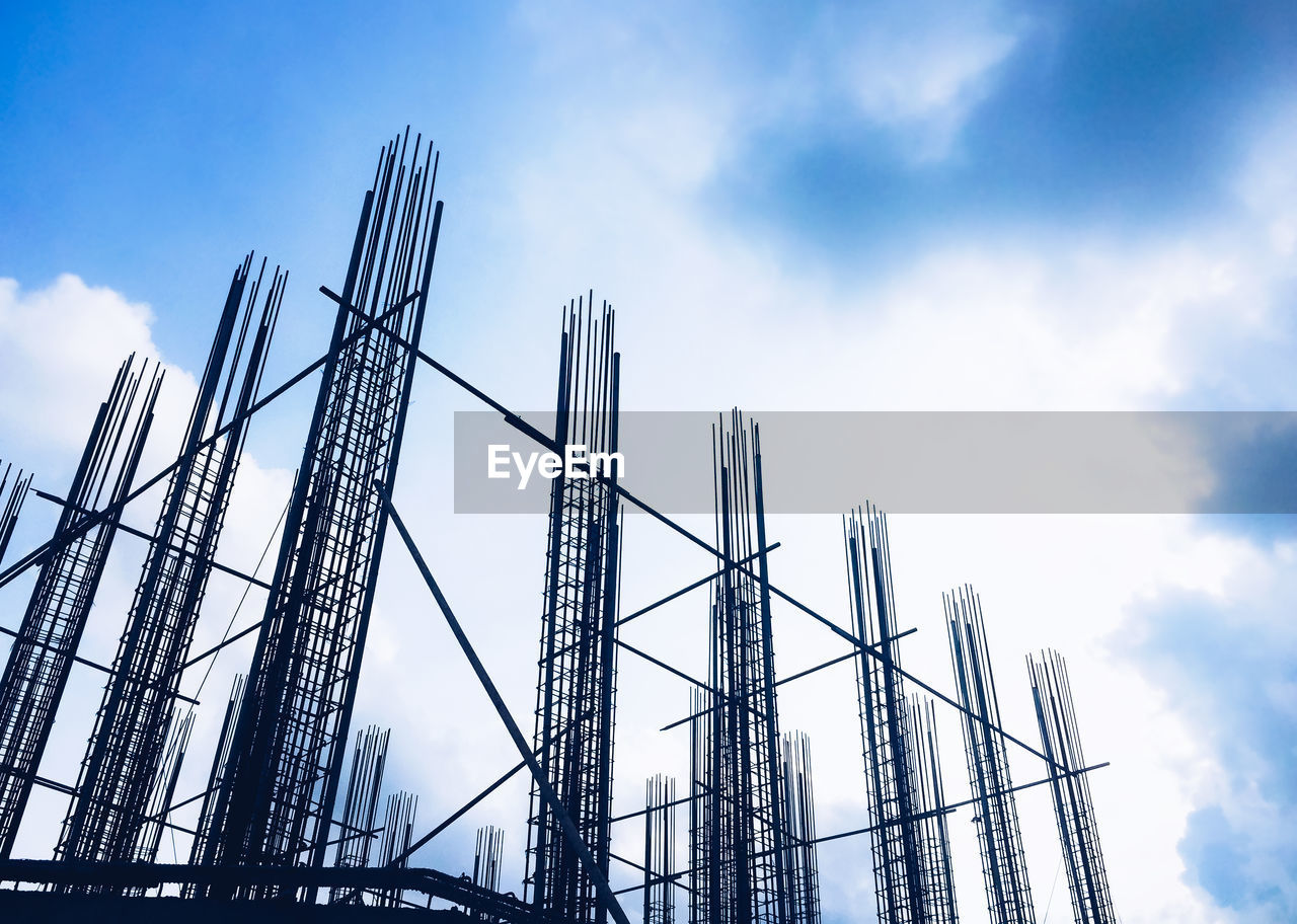 Low angle view of construction site against cloudy sky