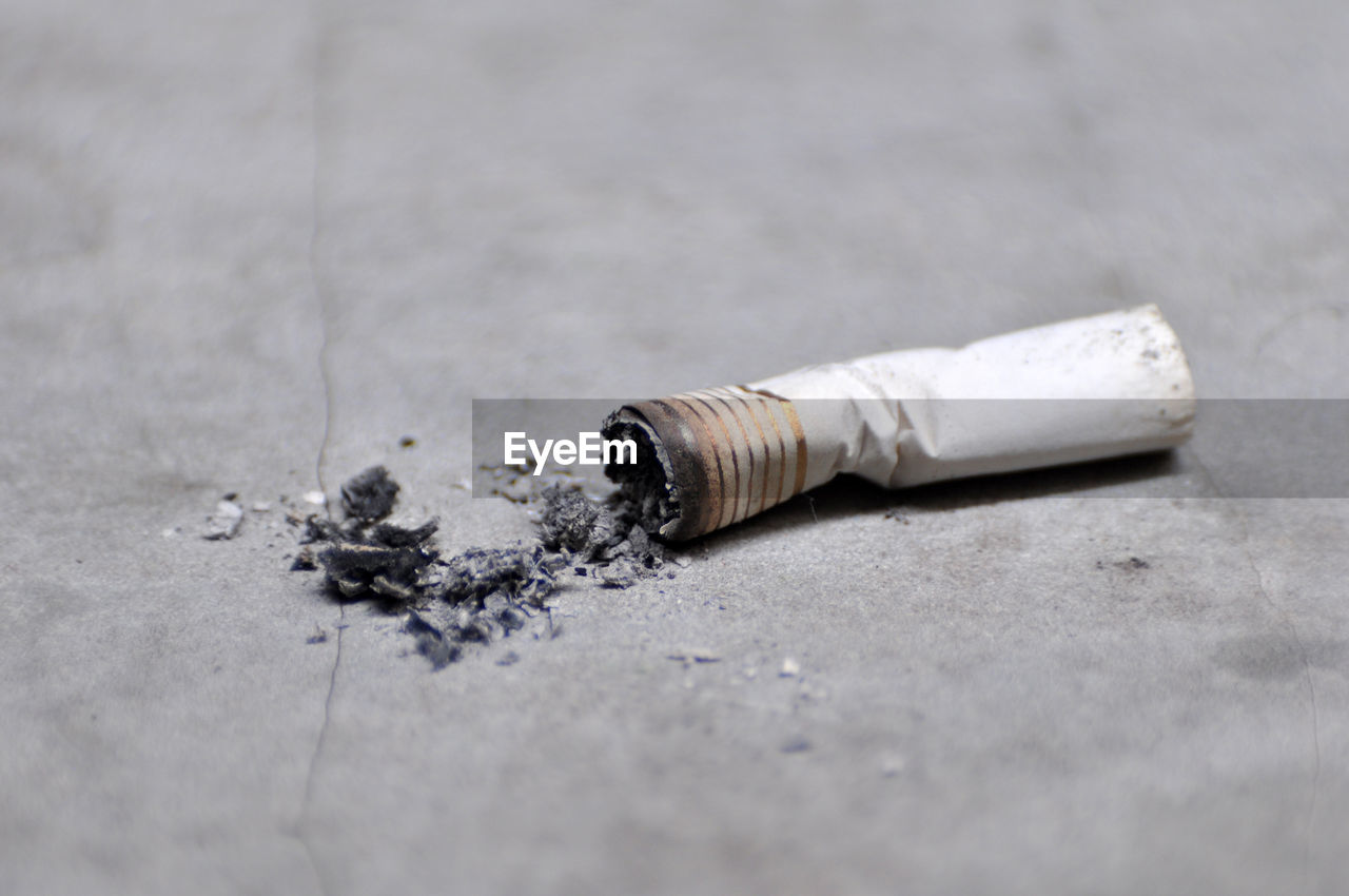 Close-up of burnt cigarette on footpath