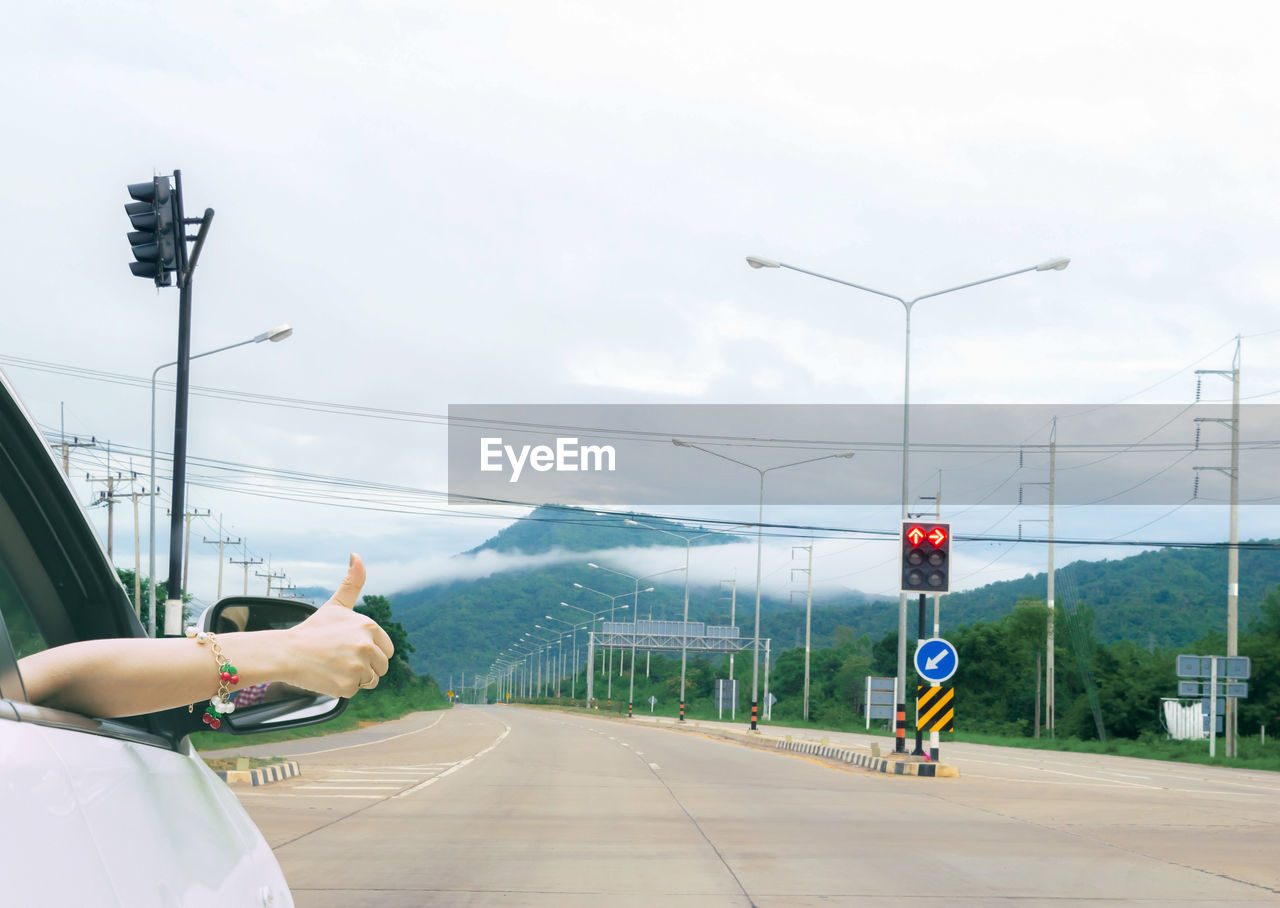 MAN ON ROAD AGAINST SKY