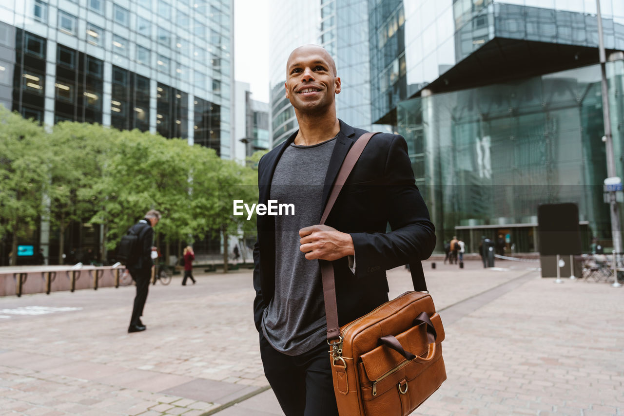 portrait of young man standing on street in city