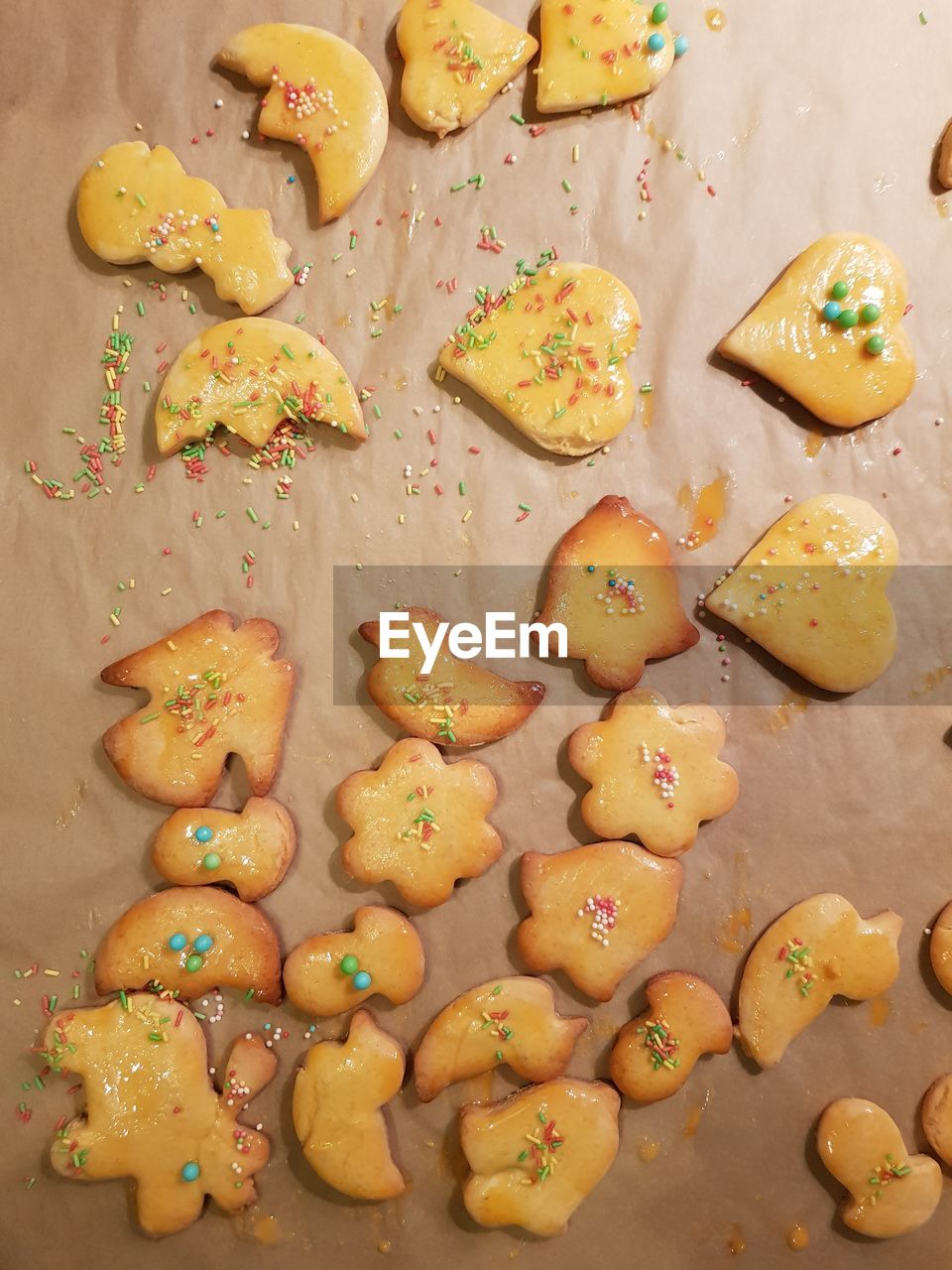 Directly above view of fresh baked cookies with sprinkles on brown paper
