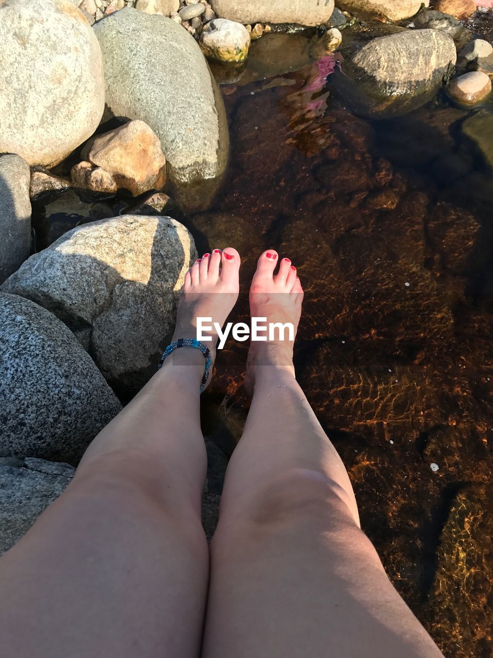 LOW SECTION OF WOMAN LEGS ON WATER