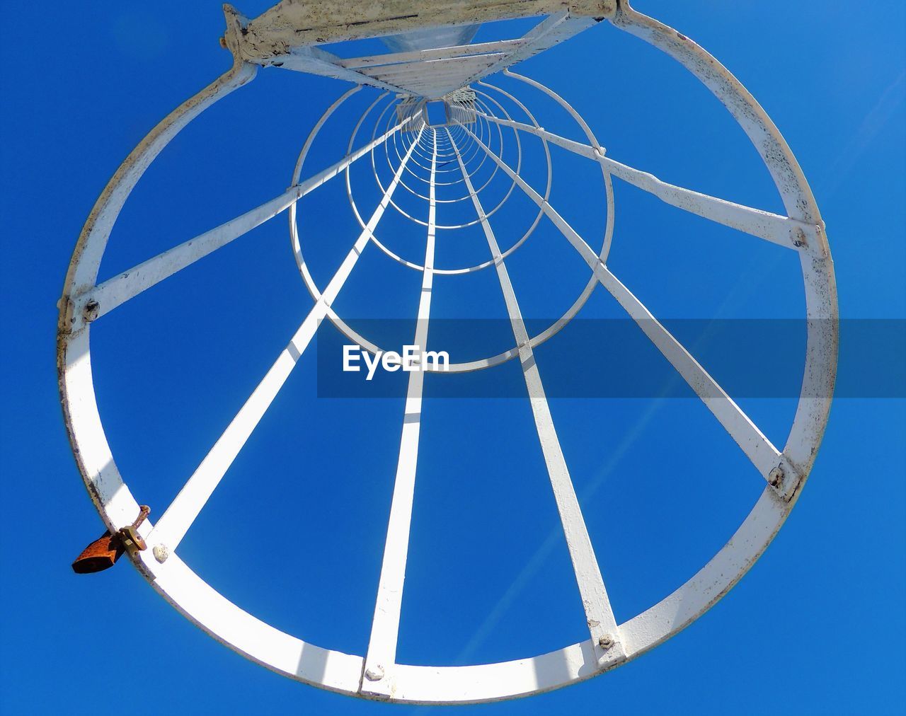 LOW ANGLE VIEW OF CHAIN SWING RIDE AGAINST BLUE SKY
