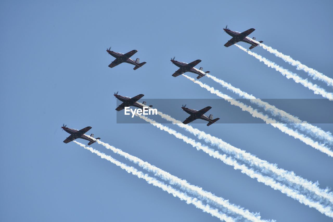 LOW ANGLE VIEW OF AIRSHOW AGAINST SKY