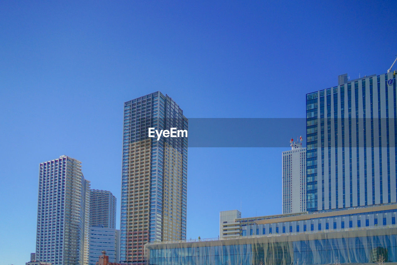 low angle view of skyscrapers against clear blue sky