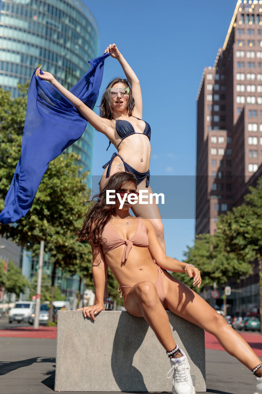Fashionable young women wearing bikinis in city