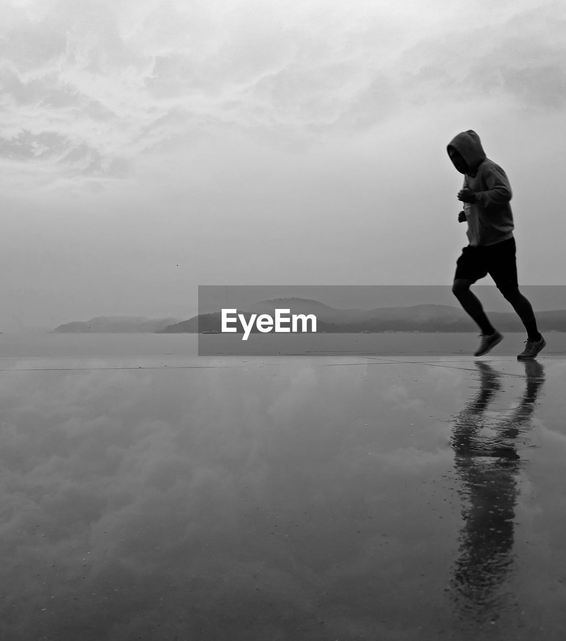 MAN ON SEA SHORE AGAINST SKY