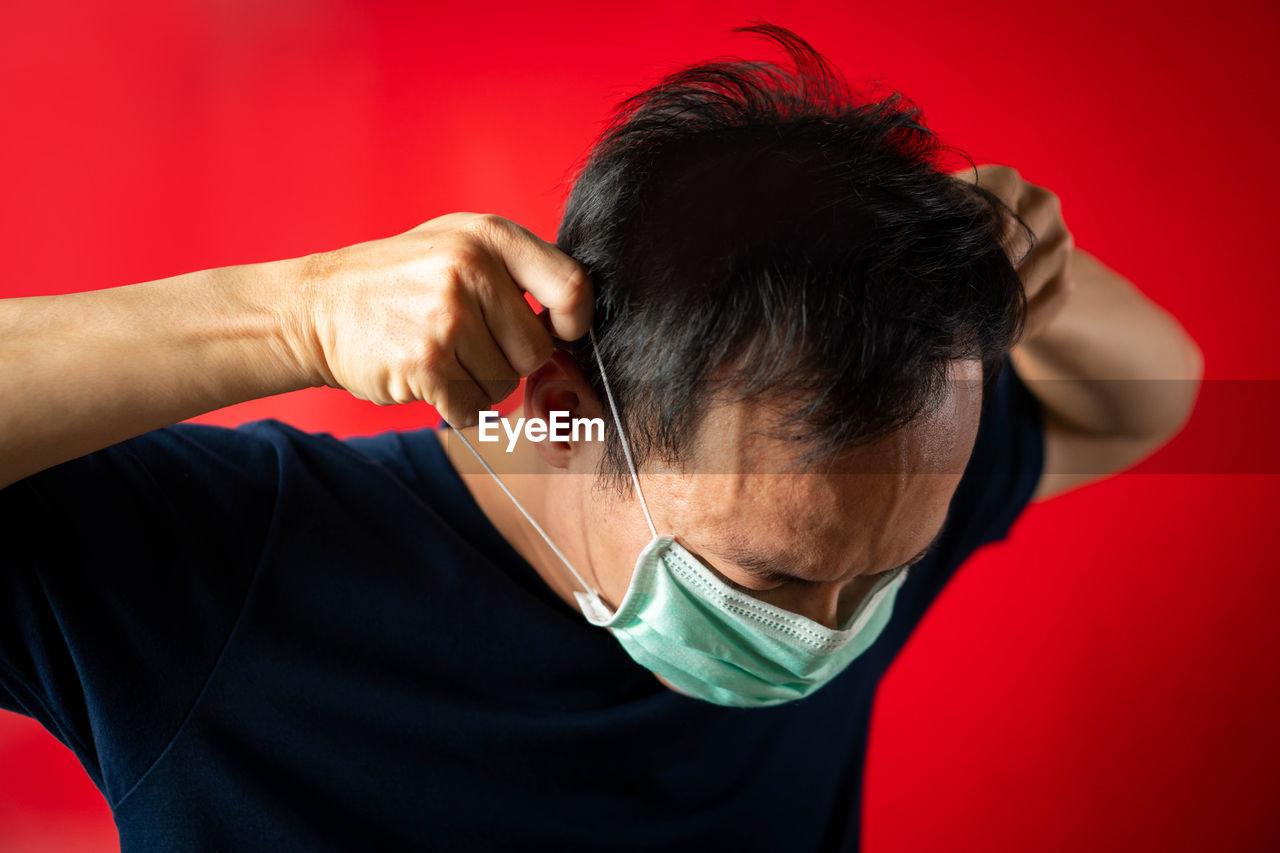 Man wearing mask against red background