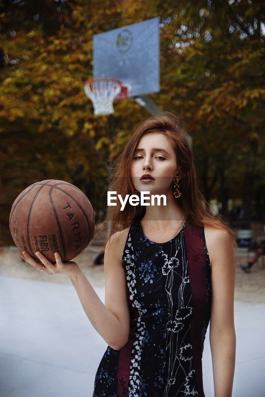 Portrait of young woman playing basketball