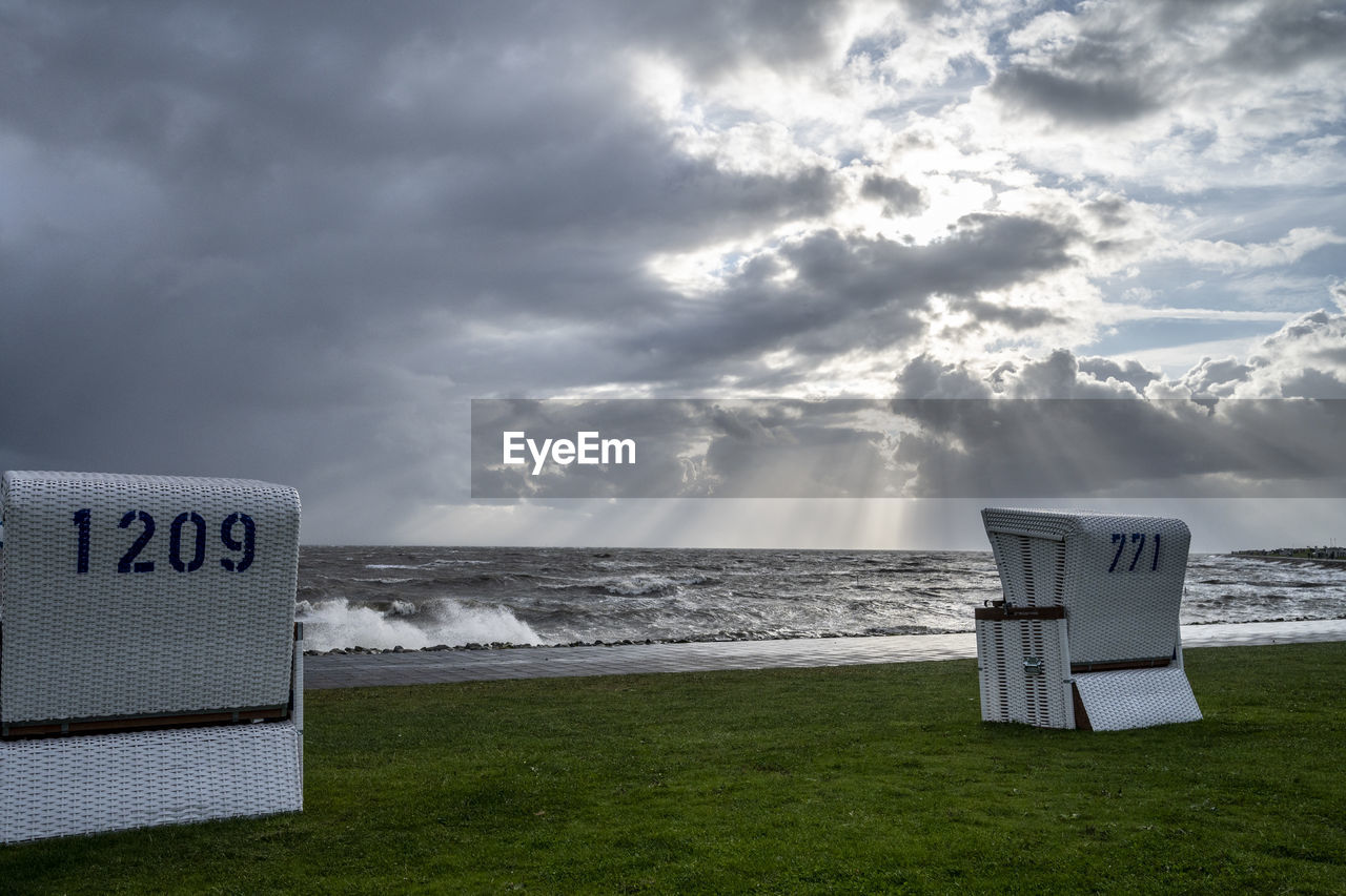 sky, cloud, sea, beach, land, horizon, water, nature, ocean, grass, coast, communication, no people, scenics - nature, wind, beauty in nature, sign, horizon over water, text, shore, environment, storm, tranquility, outdoors, day, western script, dramatic sky, plant, guidance, morning, tranquil scene, storm cloud, landscape, overcast, travel destinations, sand, travel, architecture