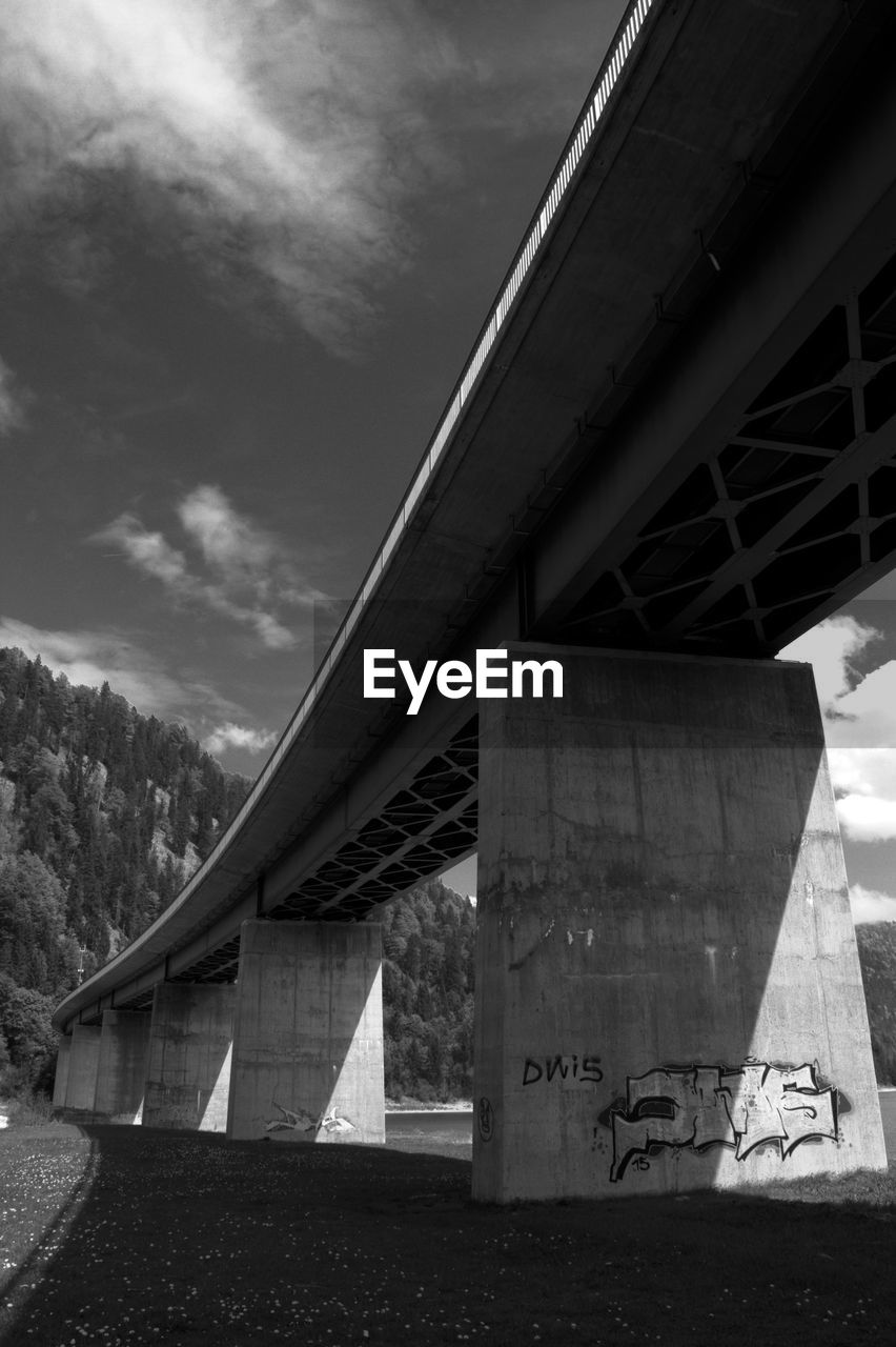 LOW ANGLE VIEW OF BRIDGE BY ROAD AGAINST SKY