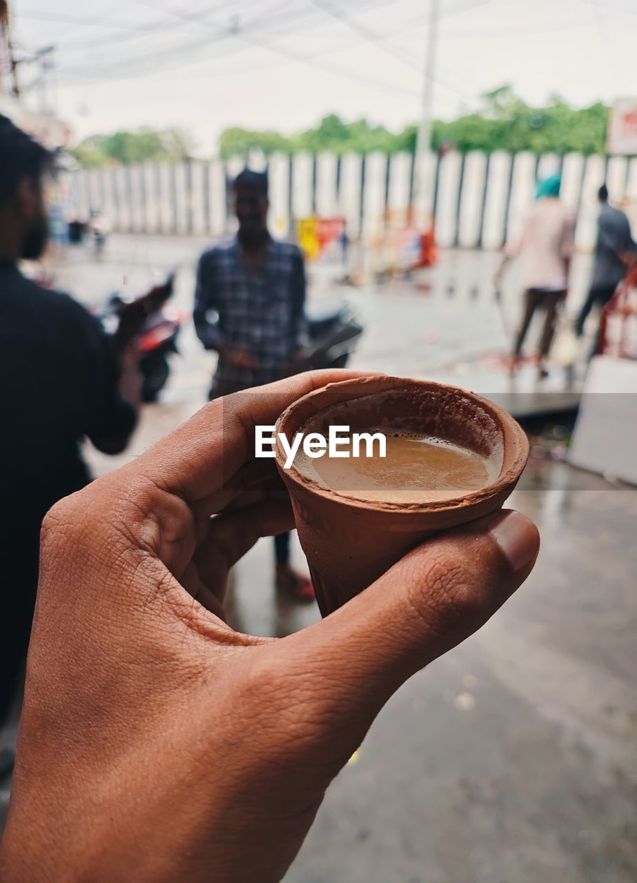 Midsection of man holding coffee cup