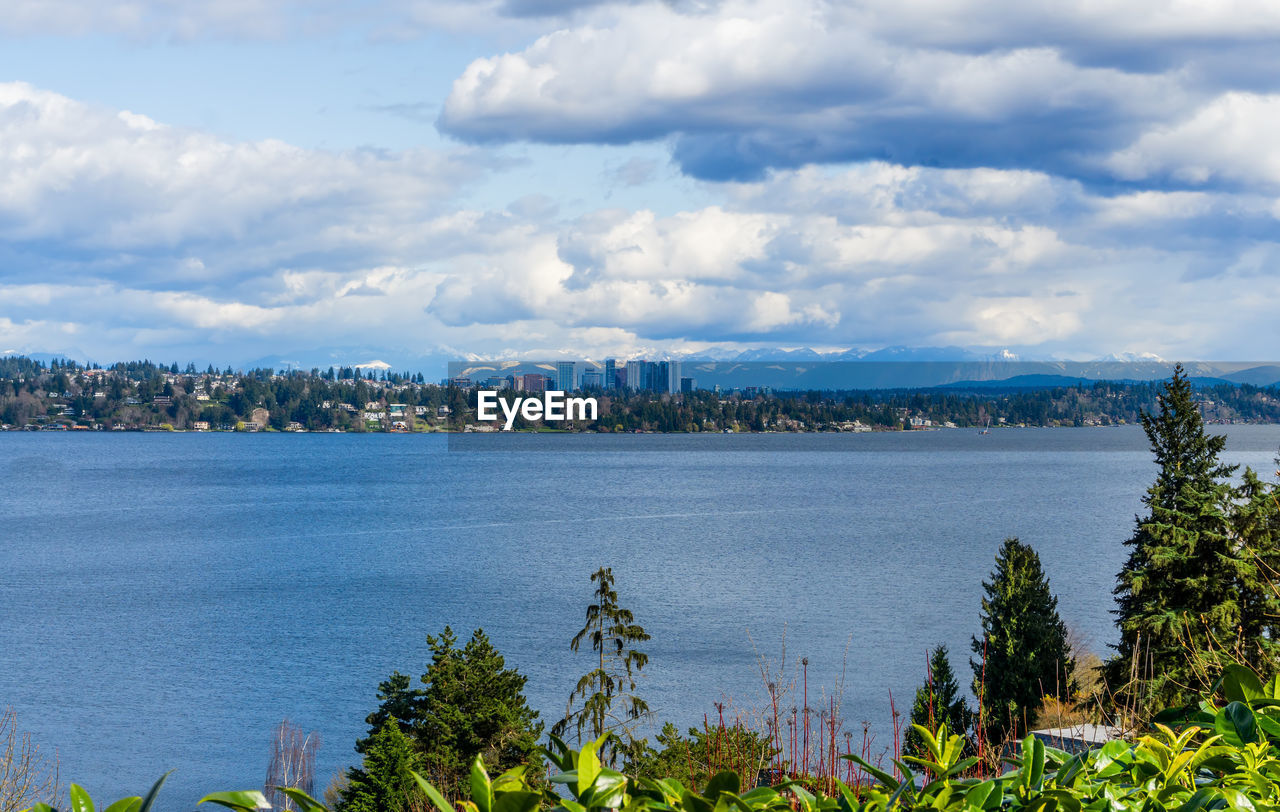 A view of the shoreline of bellevue, washington with the cascade mountains behind.