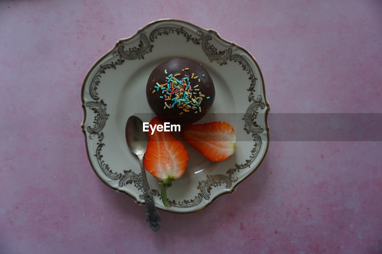 Strawberry and donut in plate on table