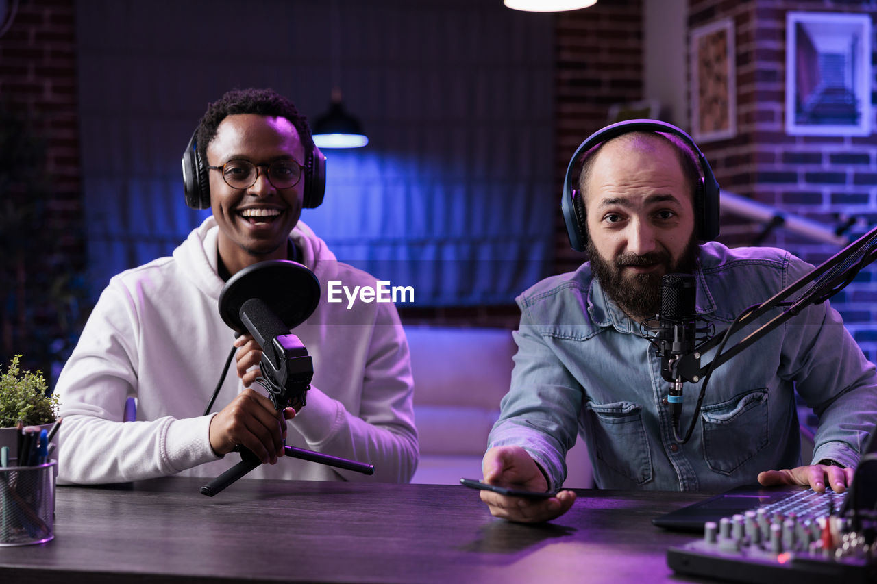 Portrait of vloggers sitting at studio