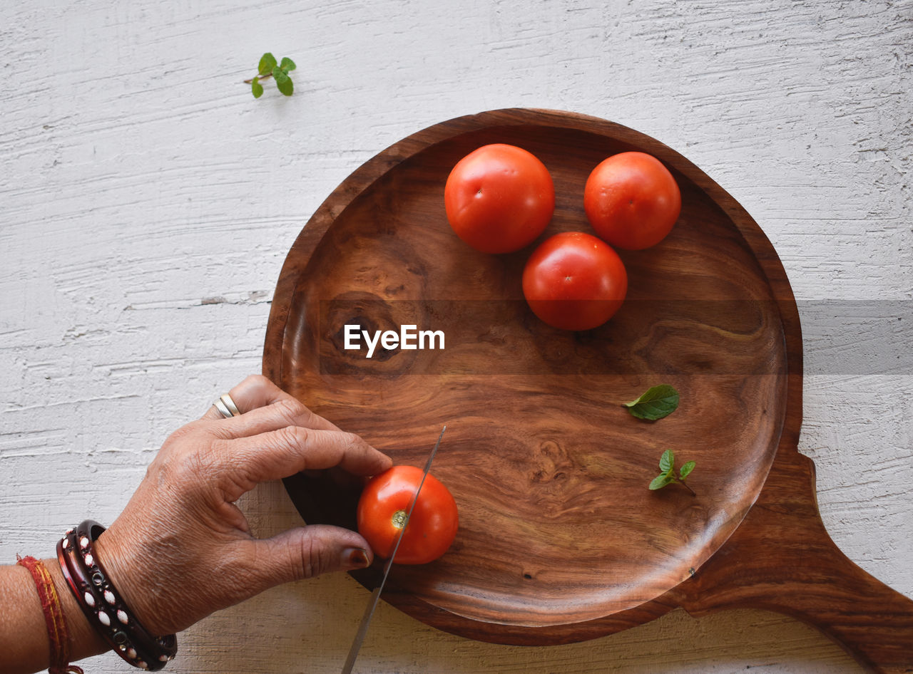 HIGH ANGLE VIEW OF PERSON HAND HOLDING APPLE