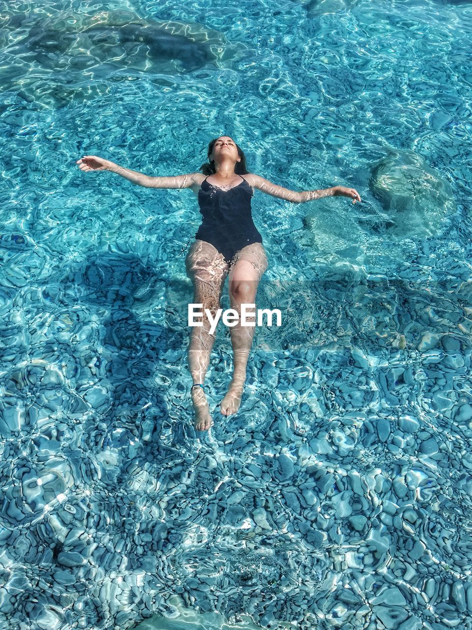 High angle view of woman relaxing in swimming pool