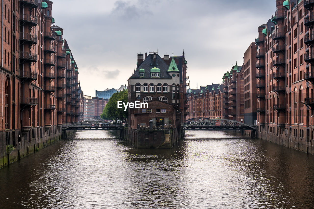 Bridge over canal amidst buildings in city