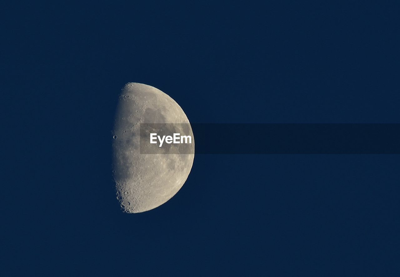 LOW ANGLE VIEW OF HALF MOON IN SKY