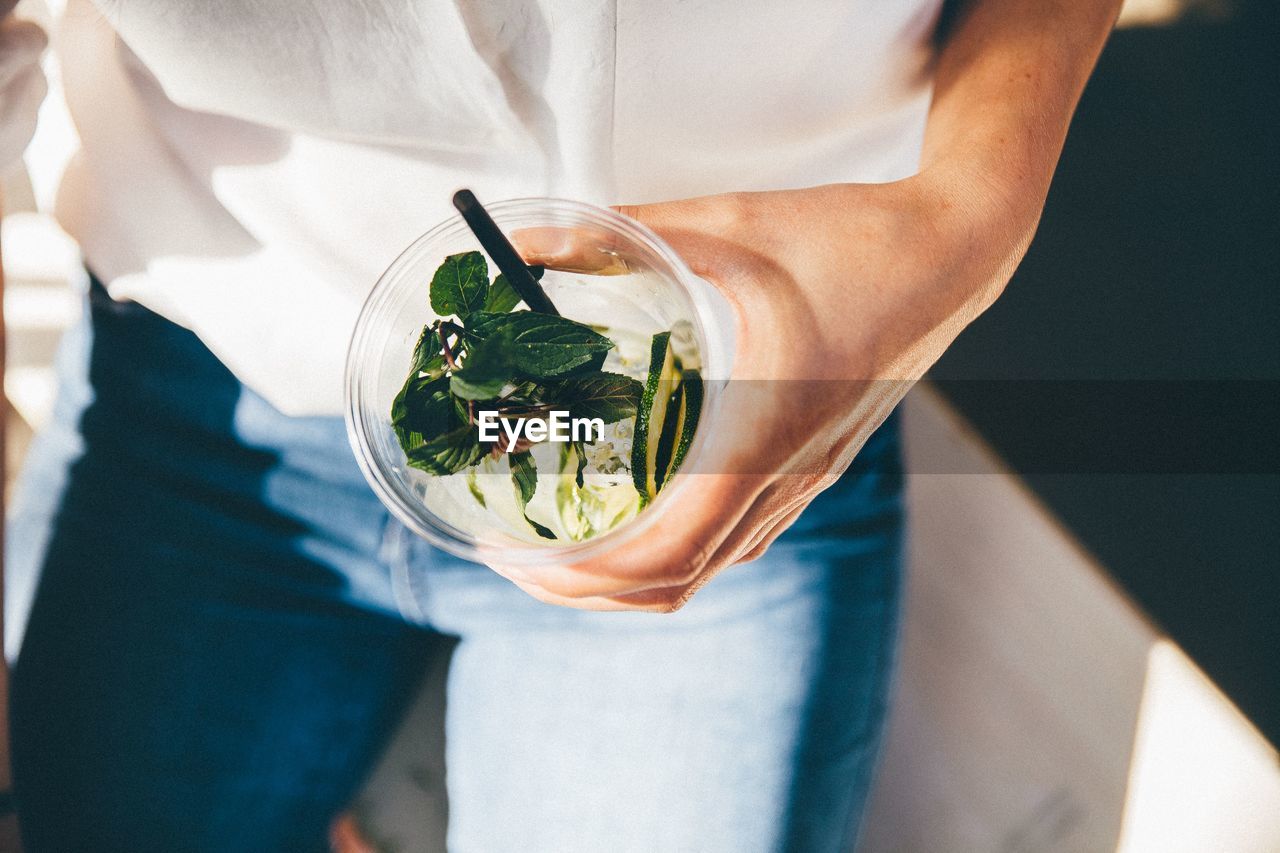 Midsection of woman holding drink