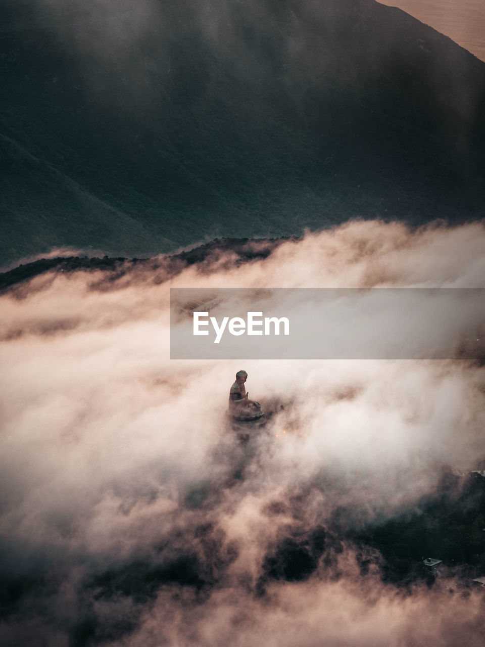 Buddha standing on mountain against sky