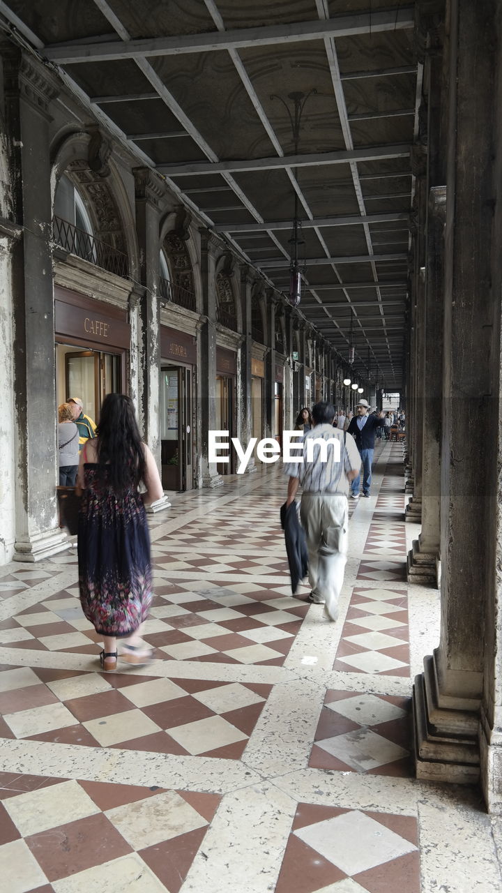 Rear view of people walking in corridor