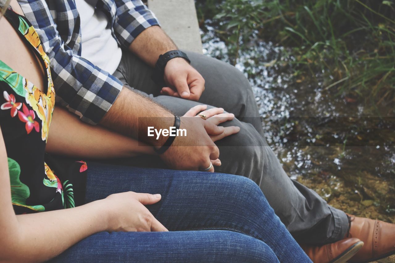 Low section of couple sitting on bench