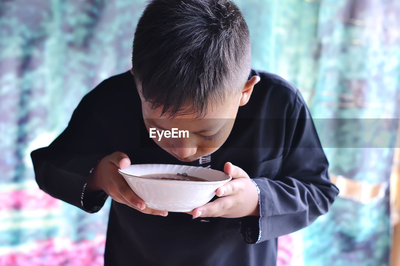 A child smells delicious food in a bowl