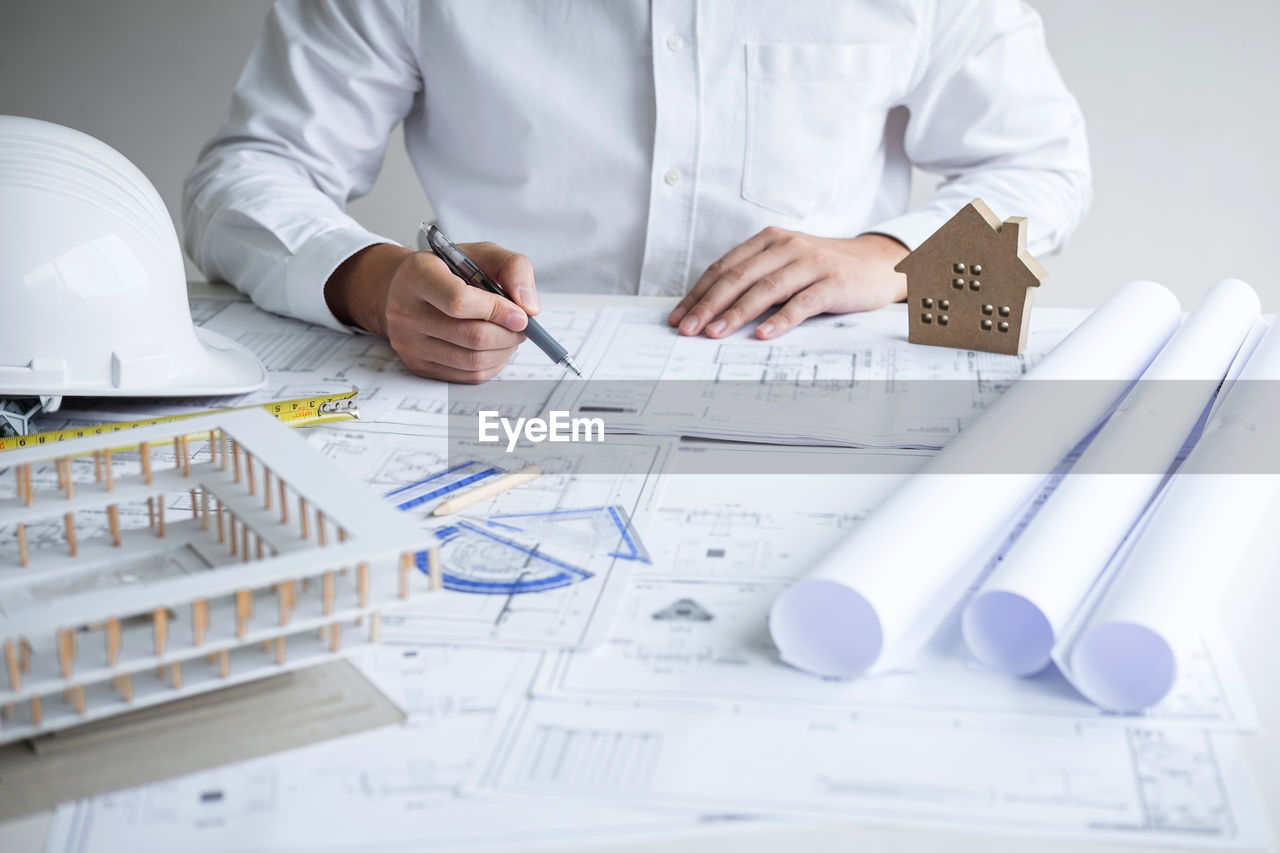 LOW ANGLE VIEW OF MAN WORKING ON TABLE WITH PEOPLE