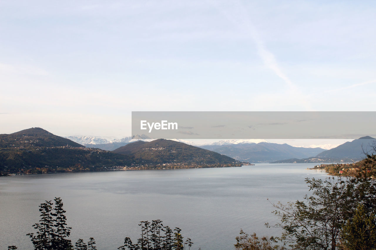 Scenic view of lake by mountains against sky