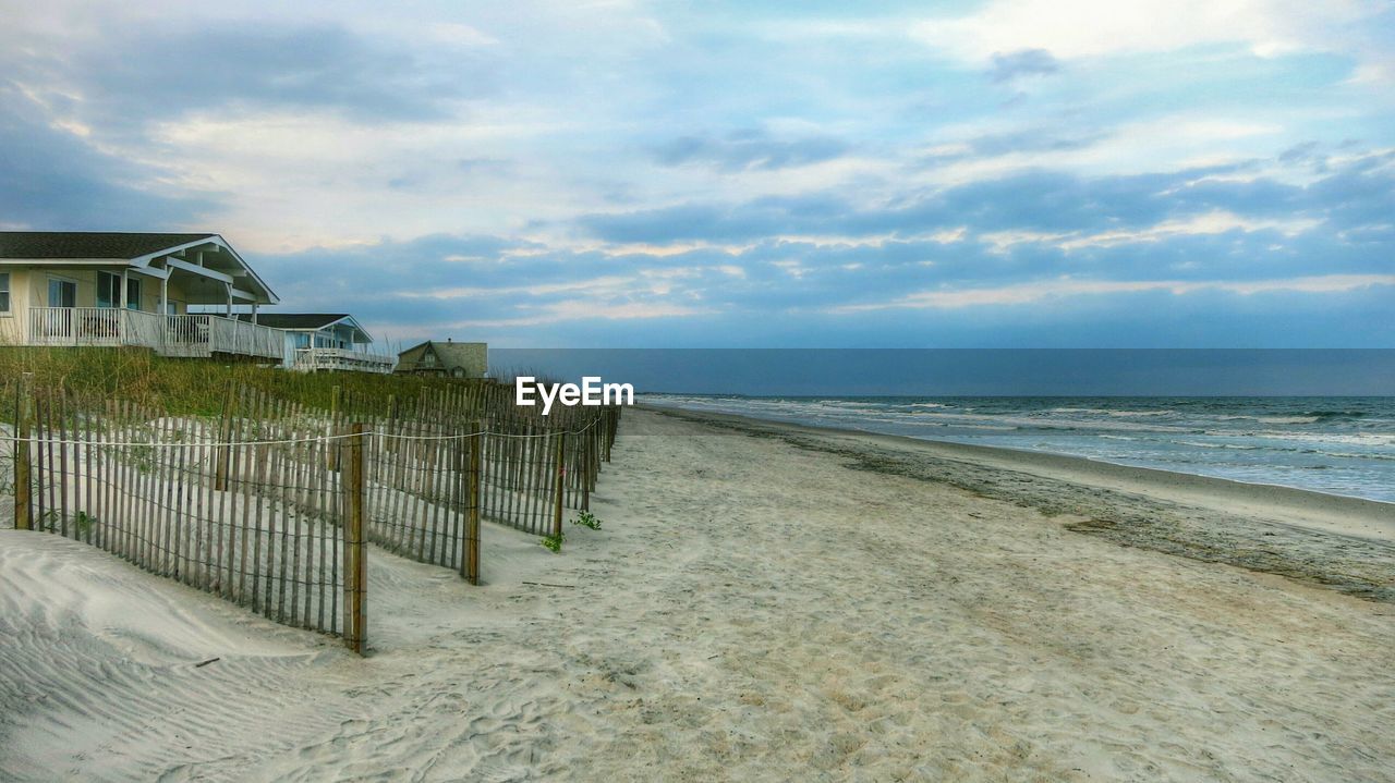 Houses at beach against sky