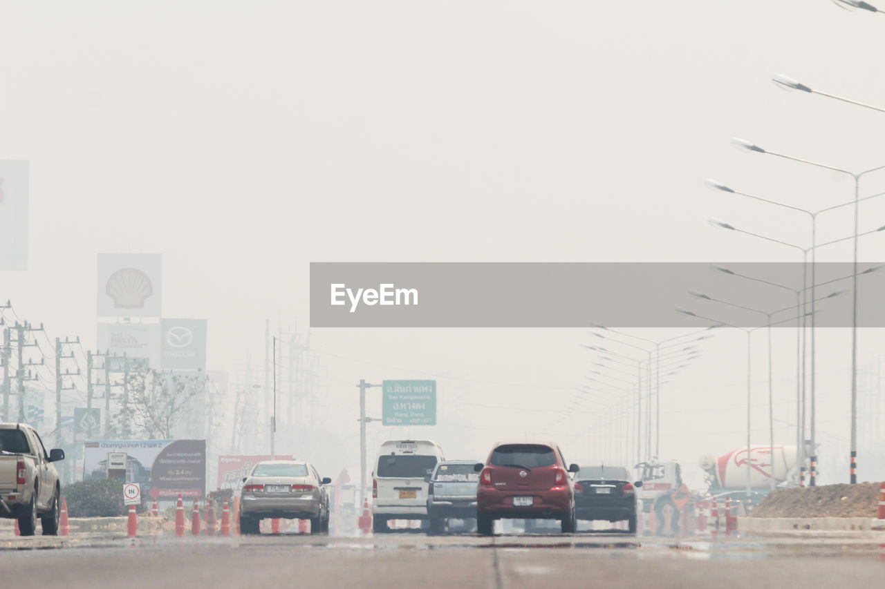 CARS ON ROAD AGAINST BUILDINGS IN CITY