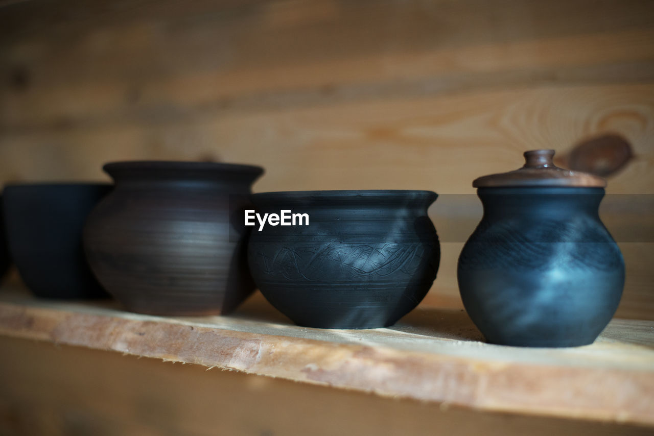 Close-up of pots on shelf at workshop