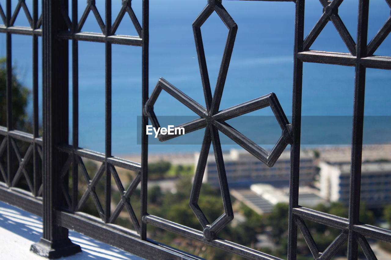 Metallic structure against sky seen through window