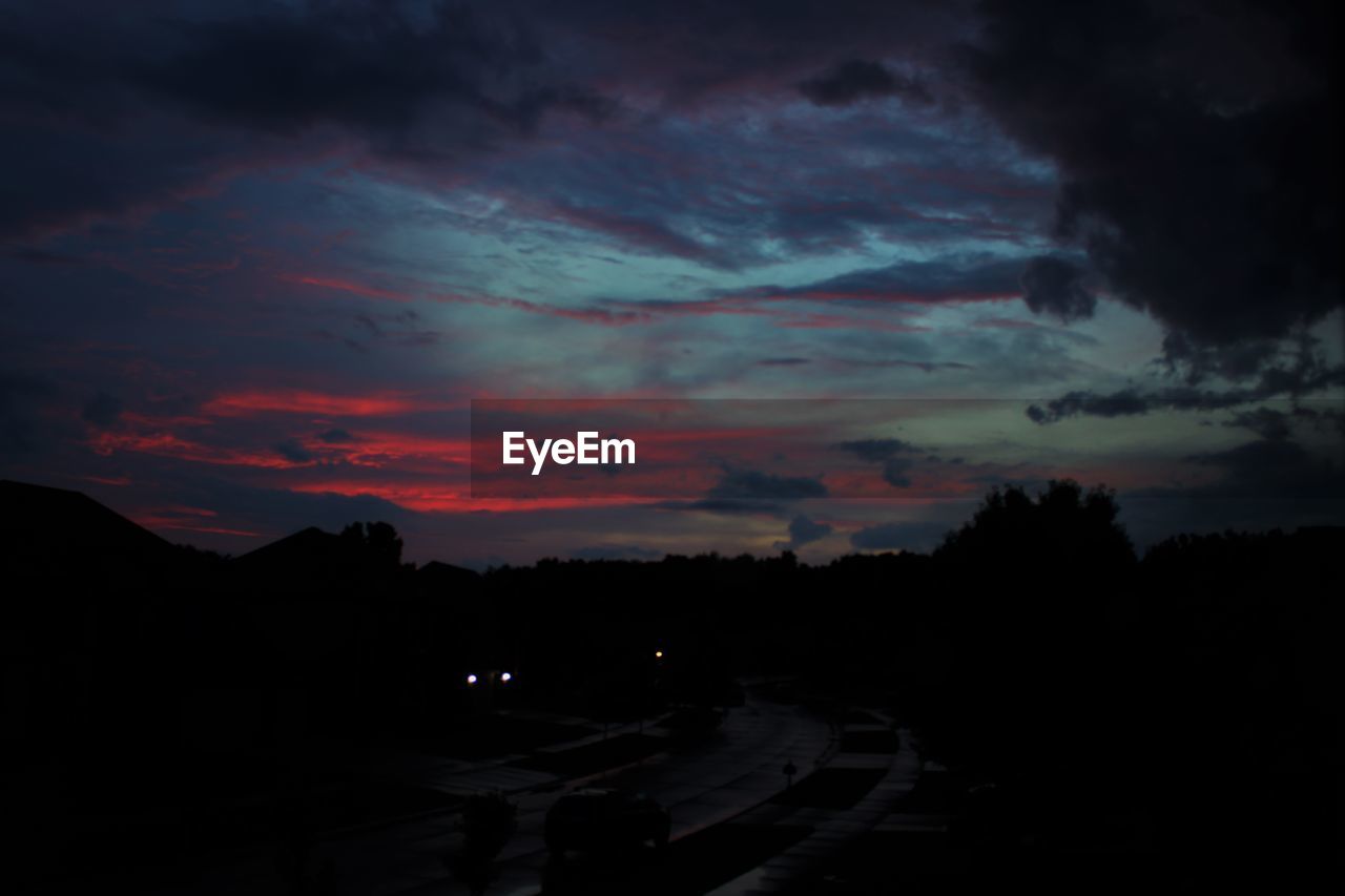 SILHOUETTE OF MOUNTAIN AGAINST DRAMATIC SKY