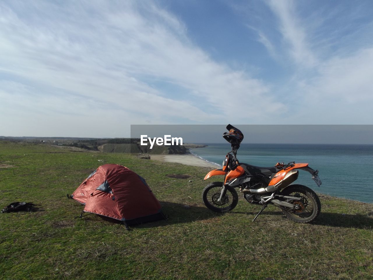 MAN RIDING MOTORCYCLE ON SEA SHORE