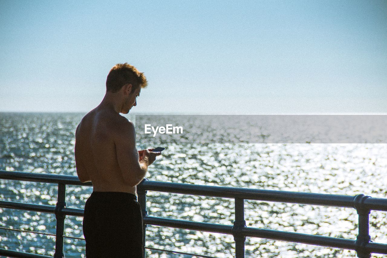 MAN LOOKING AT CAMERA ON RAILING