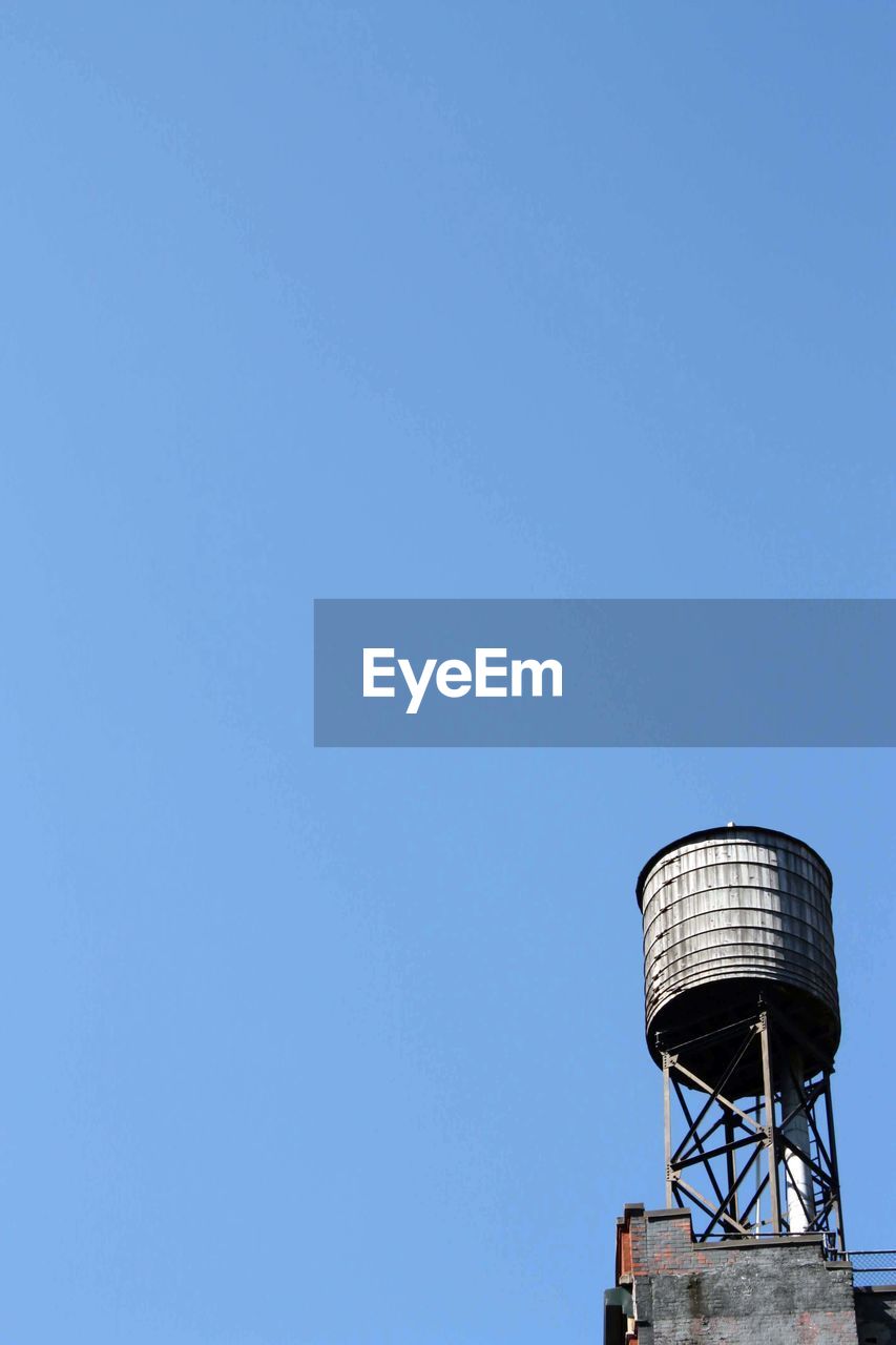 Low angle view of water tank against clear blue sky