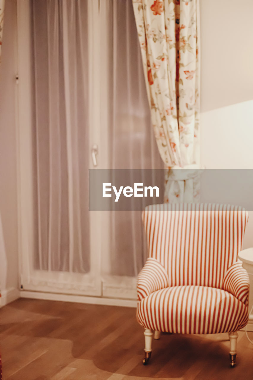 Empty armchair against window at home