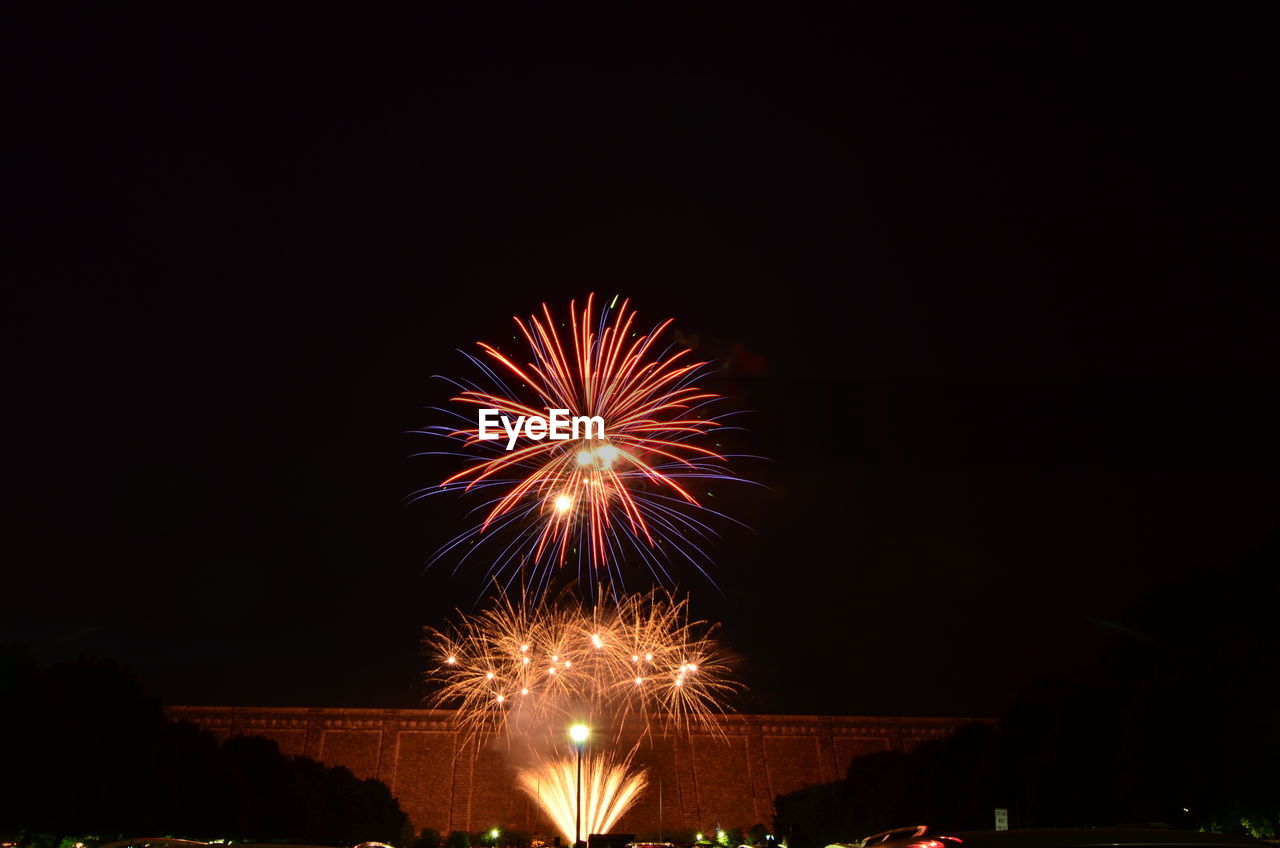 Low angle view of firework display against sky at night